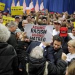 A protester holding a sign against racism and hatred is removed from U.S. Republican presidential candidate Donald Trump's campaign rally at the University of Iowa in Iowa City, Iowa, January 26, 2016. REUTERS/Scott Morgan - RTX245SQ